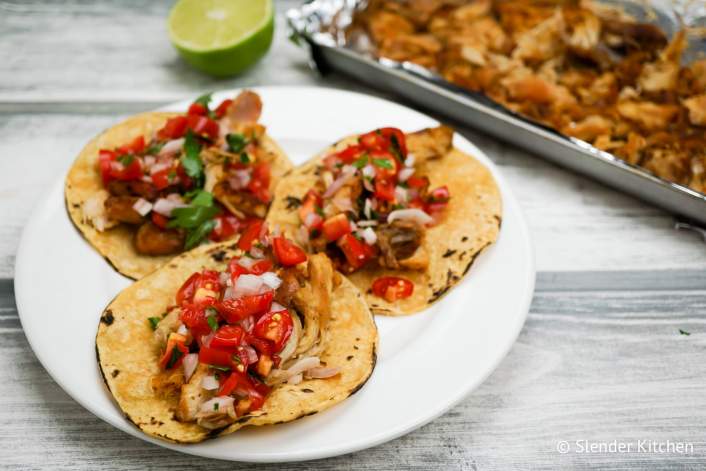 Slow Cooker Chicken Carnitas with lime juice and pico de gallo.