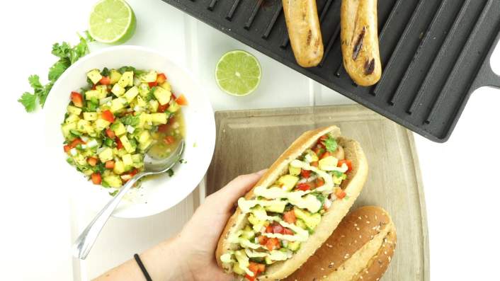 Pineapple Chicken Sausages on the grill with salsa and limes.