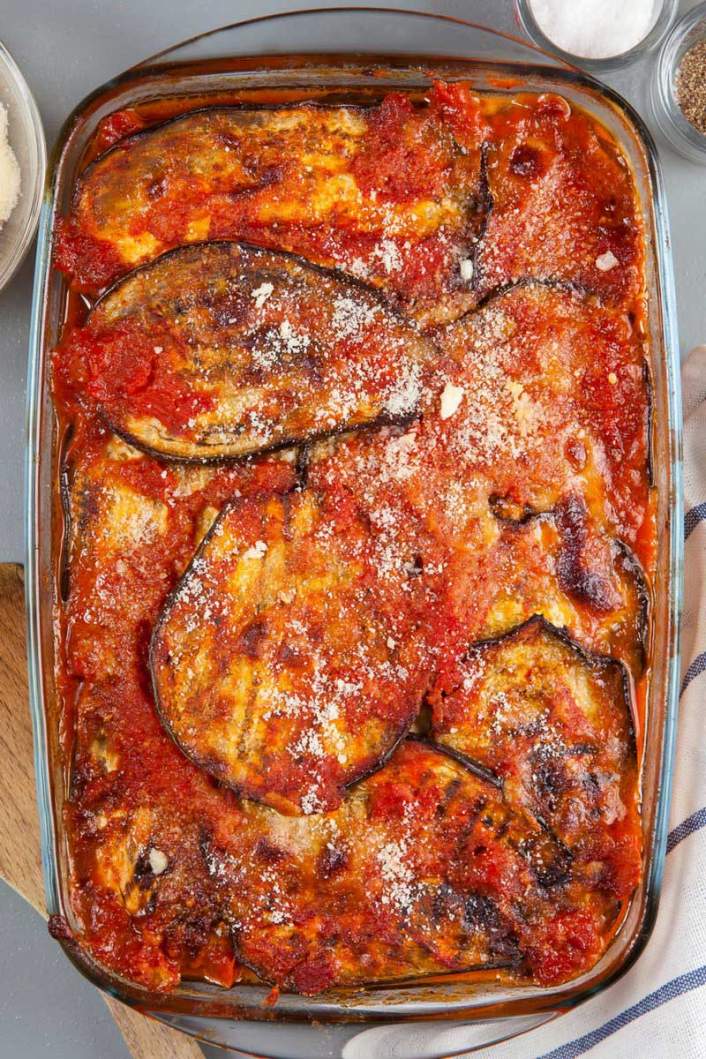 Low Carb Eggplant Parmesan in a glass dish with parmesan cheese.
