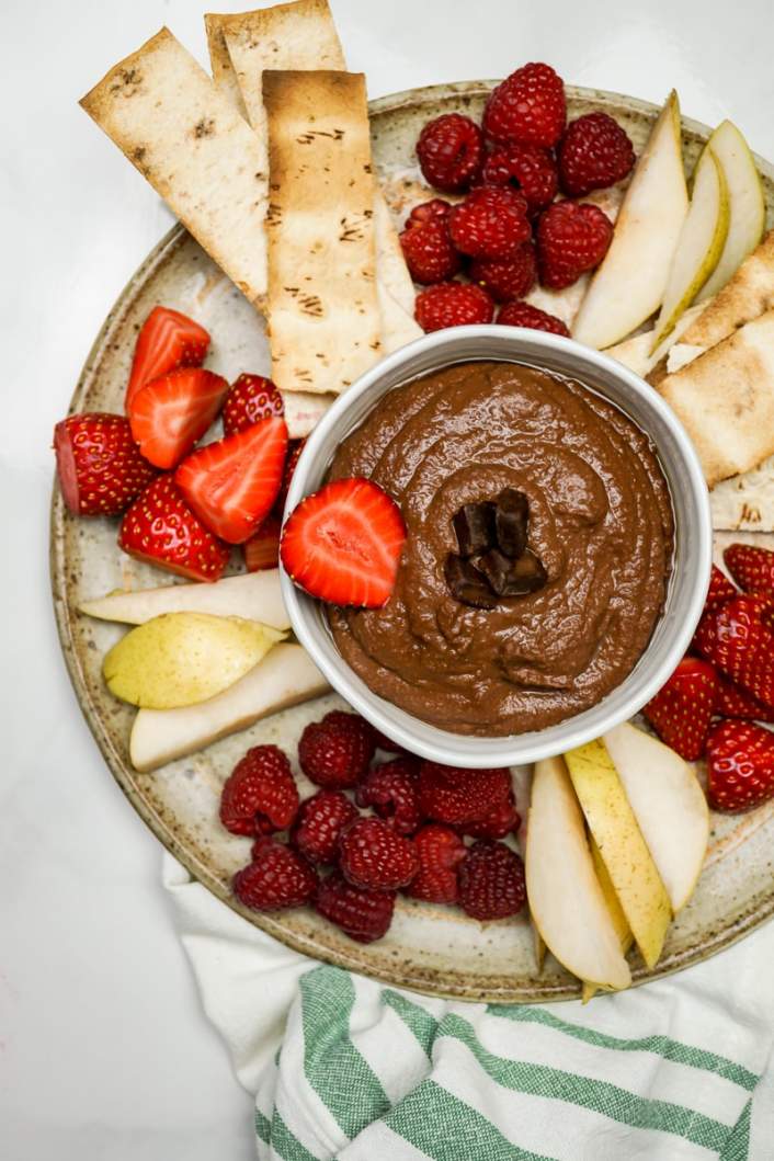 Brownie Batter Chocolate Hummus in a bowl with fruit.