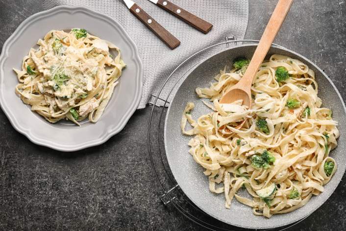 Creamy pasta with broccoli on two plates.