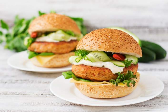 Two Tilapia Fish Burgers with greens and cucumber.