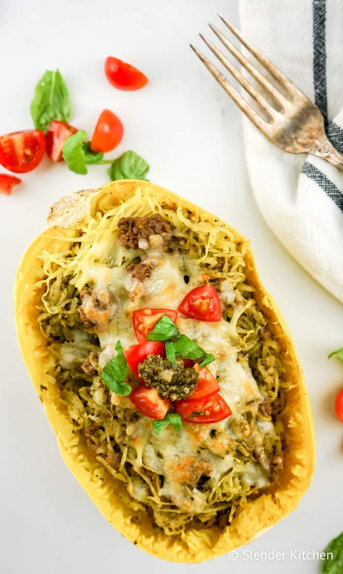 Weight Watchers Pesto Spaghetti Squash on a marble background with tomato slices.
